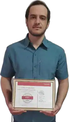 Justin John holding his certificate